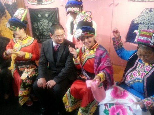 As moças da Minoria Qiang estão a apresentar a arte popular – Bordados da Minoria Qiang.